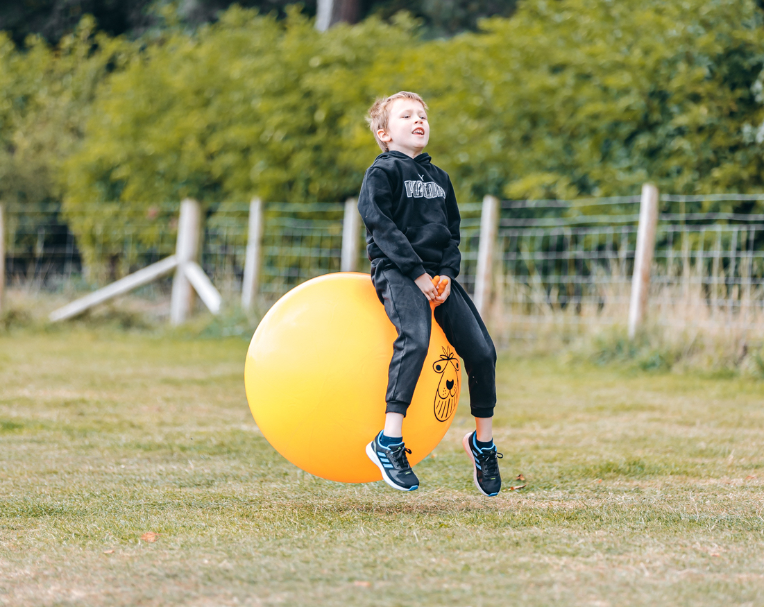 boy bouncing in the space hopper arena