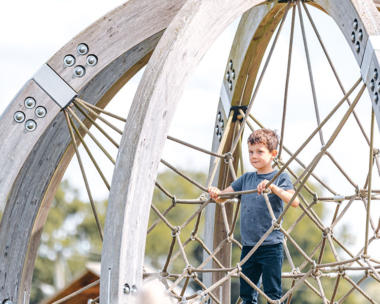 A brave child on the huge climbing globe at park hall