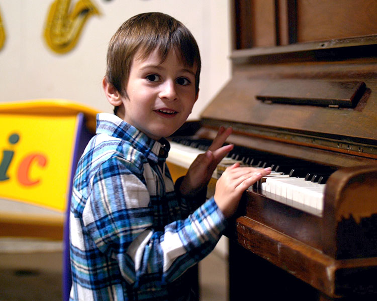 budding musician on the piano in the music room